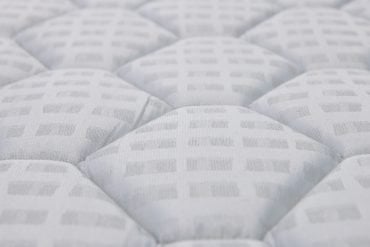 Close-up of a white quilted mattress surface and layers