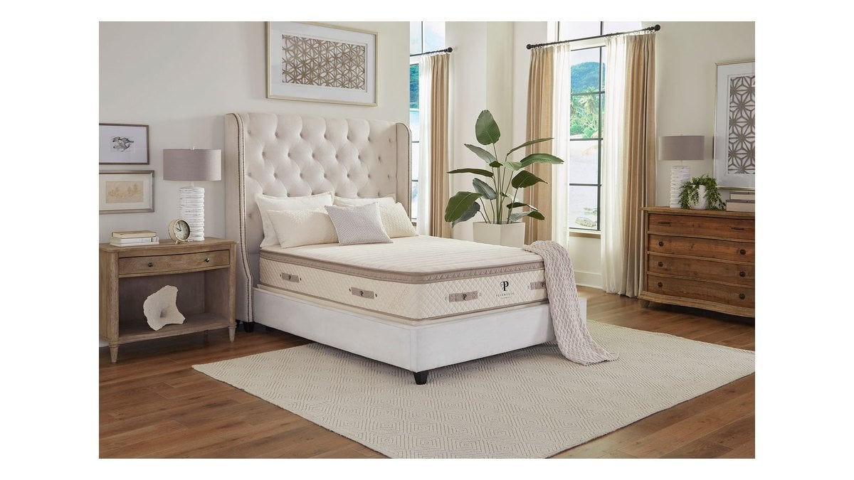 The PlushBeds Luxury Bliss hybrid latex mattress on a tufted bed