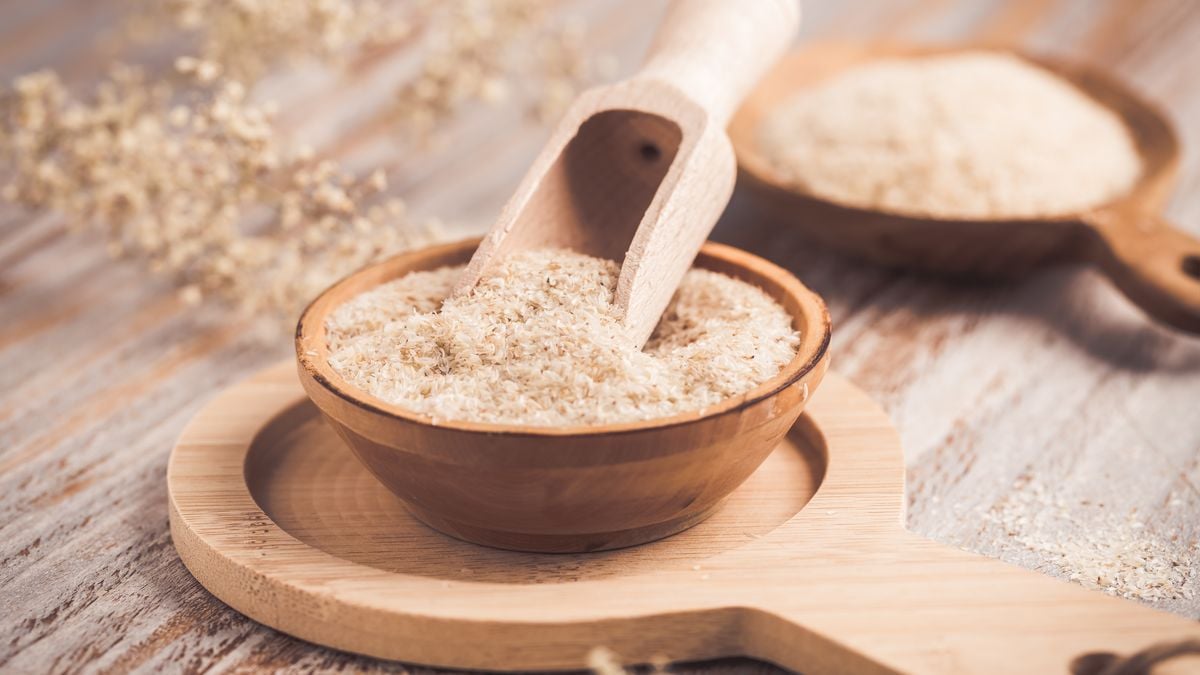 Wooden bowl of psyllium husk powder with a scoop